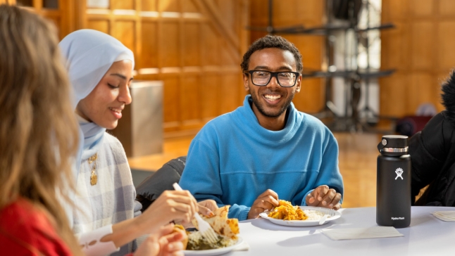 Students sitting at table dining