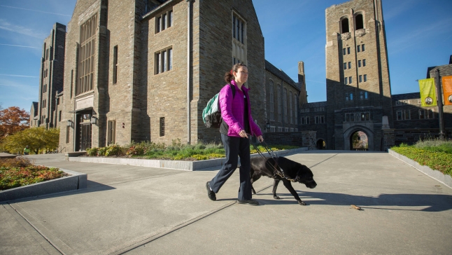 Student with guide dog walking on campus